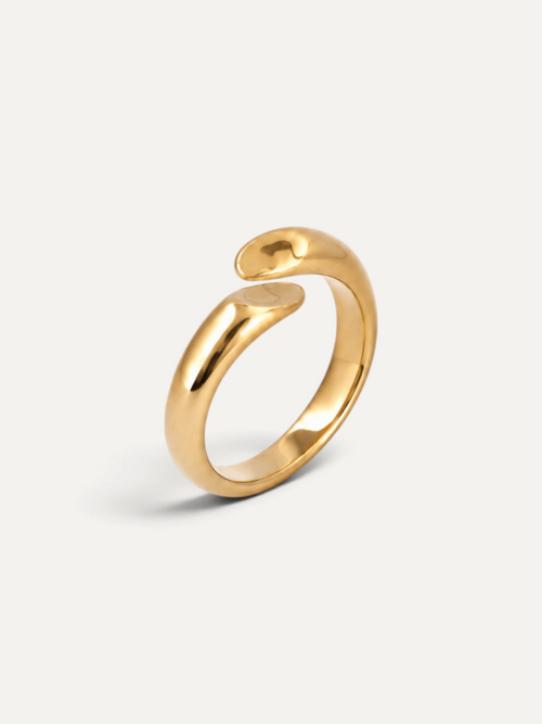 CÉLOIR Alva Ring aus goldfarbenem Edelstahl mit offenem, geschwungenem Design auf weißem Hintergrund